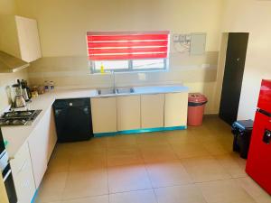 a small kitchen with a sink and a window at Simplistic Ambience At The Lekki Peninsula, Lagos in Mama