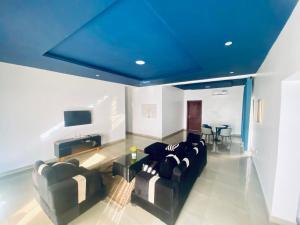 a living room with couches and a blue ceiling at Simplistic Ambience At The Lekki Peninsula, Lagos in Mama