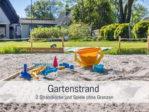 a childs sandbox with a toy in the sand at Ferienwohnung KUMM RIN - Oase an der Nordsee in Carolinensiel +56 photos