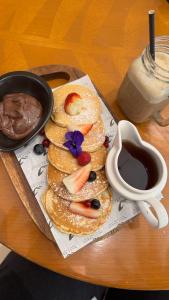 un piatto di pancake con frutta e una tazza di caffè di Gold Crest Signature One Bedroom Family Apartments - City View DHA Lahore a Lahore