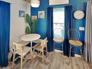 a dining room with blue walls and a table and chairs at Sand Piper in Rockport