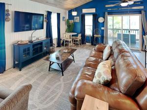 a living room with a leather couch and a table at Sand Piper in Rockport