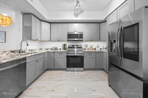 una cucina con armadietti bianchi ed elettrodomestici in acciaio inossidabile di RIVER FLY IN The Merritt Launchpad Lookout View RFI 2BR QQ Launch a Audubon Altre 20 foto