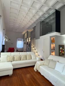 un soggiorno con divani bianchi e soffitto di LE ORSOLINE Luxury Apartment a Ferrara