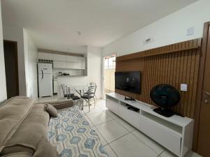 Una sala de estar con un sofá y un televisor de pantalla plana. en Apto mobiliado e aconchegante - 3 quartos, 4 camas, 2 banheiros - Lazer completo e localização privilegiada, en João Pessoa