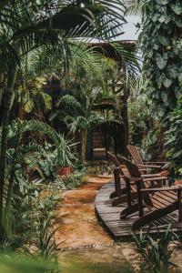 a wooden walkway with benches and palm trees at Pousada Fortal Jeri in Jericoacoara