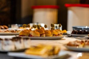 a table topped with plates of food with spoons at Maar Hotel Brezovice in Prevallë