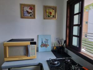 Um micro-ondas e um fogão na cozinha em Kitnet Minimalista Mezanino em São Paulo