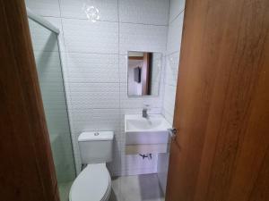 um banheiro com vaso sanitário e pia em Kitnet Minimalista Mezanino em São Paulo mais 8 fotografias