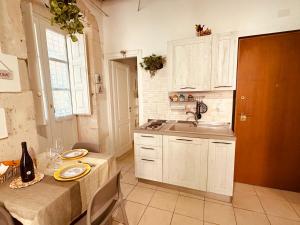 eine Küche mit weißen Schränken und einer Spüle in der Unterkunft Ortilì in Syrakus
