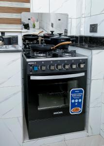 Un horno negro con un cartel en una cocina. en DPE Apartments, en Kumasi 7 fotos más