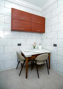 Una mesa de comedor con sillas y un armario. en DPE Apartments, en Kumasi