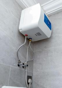 Un calentador de agua en un baño en una pared. en DPE Apartments, en Kumasi