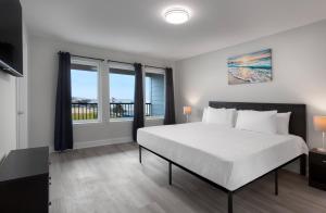 a bedroom with a large bed and windows at Ocean Escape Boardwalk Oceanfront in Myrtle Beach