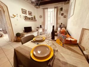ein Esszimmer mit einem Tisch, auf dem gelbe Teller stehen in der Unterkunft Ortilì in Syrakus