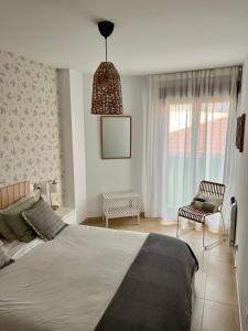 Un dormitorio con una cama, una silla y una ventana en Ondas do Mar Boutique Stays - Portonovo 4, en Portonovo