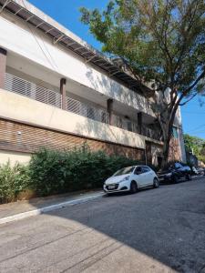um carro branco estacionado em frente a um prédio em Kitnet Minimalista Mezanino em São Paulo