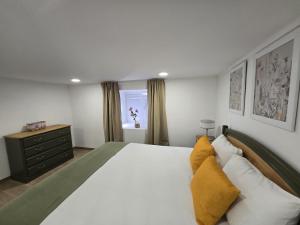 a bedroom with a large white bed with yellow pillows at Casa Lage da Pena in Geres
