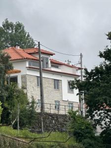 een groot wit huis op een stenen muur bij Casa Lage da Pena in Geres