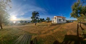 a park with a bench in a field with a building at Casas rurales La Colada in El Viso