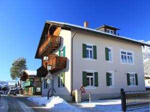 a large white building with green shutters on a street at Höllental heritage house - Alpspitzblick - 1 in Garmisch-Partenkirchen