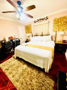 Un dormitorio con una cama grande y un ventilador de techo. en Cozy home, en Pompano Beach