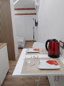 een tafel met een waterkoker en borden erop bij B&b Carlotta in Pozzuoli