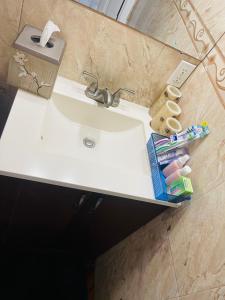 Un lavabo de baño con pasta de dientes y cepillos de dientes encima. en Cozy home, en Pompano Beach