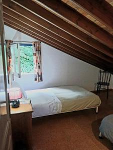 Un dormitorio con una cama y una mesa y una ventana. en Casa da Belavista, en Furnas