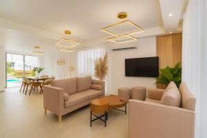 a living room with two couches and a tv at Casa Luma Vistacana in Pueblo Bavaro