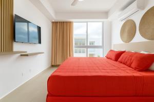 a red bed in a room with a large window at Casa Luma Vistacana in Pueblo Bavaro +18 photos