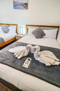 a hotel room with two beds with towels on the bed at The Victoria Inn in Truro