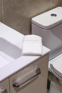 a bathroom with a white toilet and a sink at L'Etincelle 2 chambres à deux pas de la Gare in Kenitra +16 photos