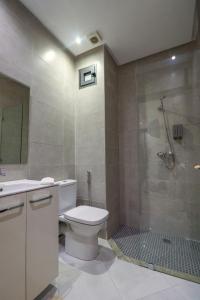 a bathroom with a toilet and a glass shower at L'Etincelle 2 chambres à deux pas de la Gare in Kenitra