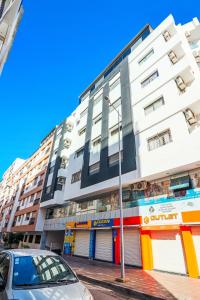 a building with a car parked in front of it at L'Etincelle 2 chambres à deux pas de la Gare in Kenitra