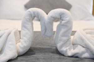 two towels shaped like swans sitting on a bed at The Victoria Inn in Truro +29 photos