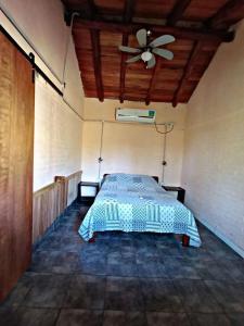 El Mangrullo في فيديراسيون: غرفة نوم بها سرير ومروحة سقف