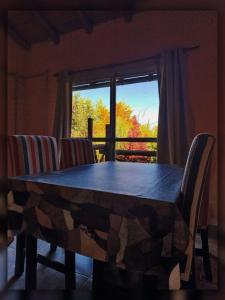 El Mangrullo في فيديراسيون: طاولة وكراسي في غرفة بها نافذة