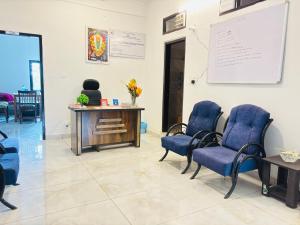 una sala de espera con sillas azules y una pared blanca en Aroha home stay, en Pālampur 16 fotos más
