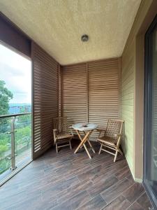 Un patio con una mesa y sillas en un balcón. en Lux Apartment in Dreamland Oasis, en Chakvi