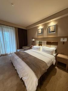 Un dormitorio con una cama grande en una habitación de hotel. en Lux Apartment in Dreamland Oasis, en Chakvi