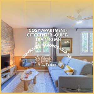 a living room with a blue couch and a wall at Les Esclafidous, centre ville- Proche Arènes & Maison Carrée in Nîmes