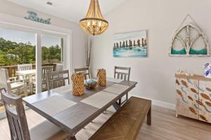 Un comedor con una mesa y sillas y una lámpara de araña. en CP117B - Sunrise Promise, en Kill Devil Hills