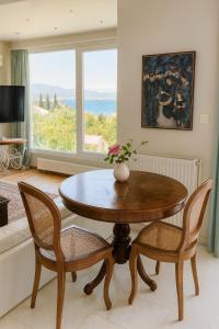 a living room with a table and chairs and a window at Caecilia & Lawrence Villa in Chalkida +22 photos