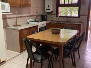 Quinta Hostaco في سان نيكولاس دي لوس أرويوس: مطبخ مع طاولة خشبية وبعض الكراسي +16 صورة