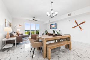 Una sala de estar con una mesa de comedor y un sofá. en RIVER FLY IN Coastal Penthouse Panoramic Views RFI 3BR KQQ Pano, en Audubon