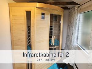 a wooden medicine cabinet in a room with a window at Ferienwohnung KIEK RUT - Gartenstrand, Wallbox & Sauna, alles für die Familie, zusätzlicher Loft in Harlesiel in Wittmund