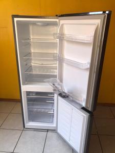 Cabañas Mami Kiki 2 في بانغويبولي: ثلاجة فارغة وبابها مفتوح في مطبخ