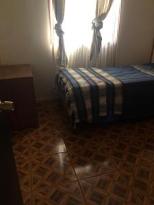 Cabañas Mami Kiki 2 في بانغويبولي: غرفة نوم بسرير مع نافذة وأرضية خشبية