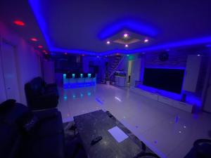 a room with blue lights and a stage with a tv at Stort luksus Villa in Søborg